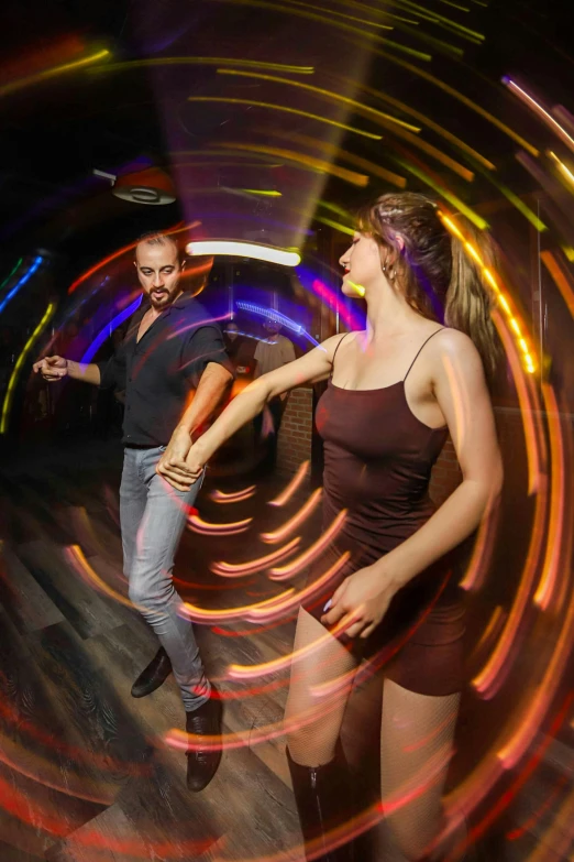 a person standing next to another man on a dance floor
