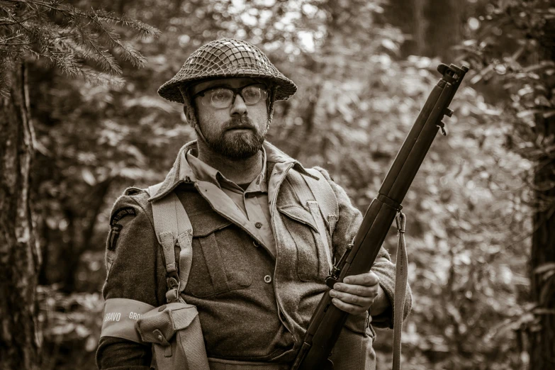 man wearing vintage look clothes and holding a gun in forest