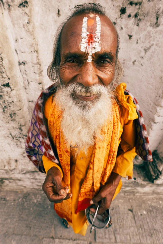 a man with a large beard wearing white painted forehead