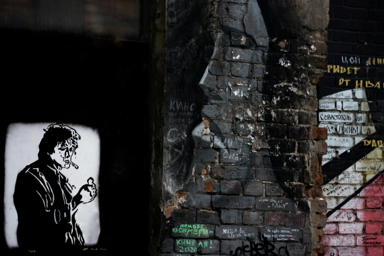 a brick wall has grafitti of a man smoking a cigarette