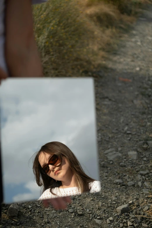 a woman's face seen in the reflection of a mirror