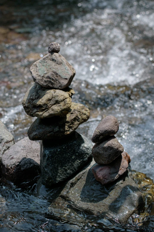 a group of rocks sitting on top of a body of water