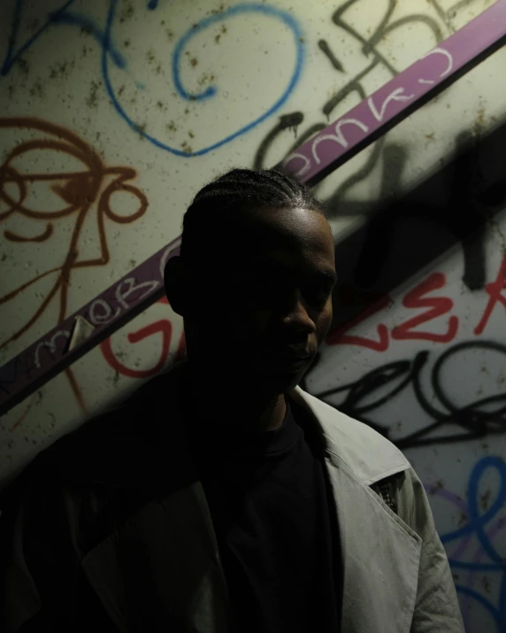 man in dark against graffiti wall with mirror