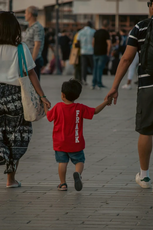 a man and woman holding the hand of a child