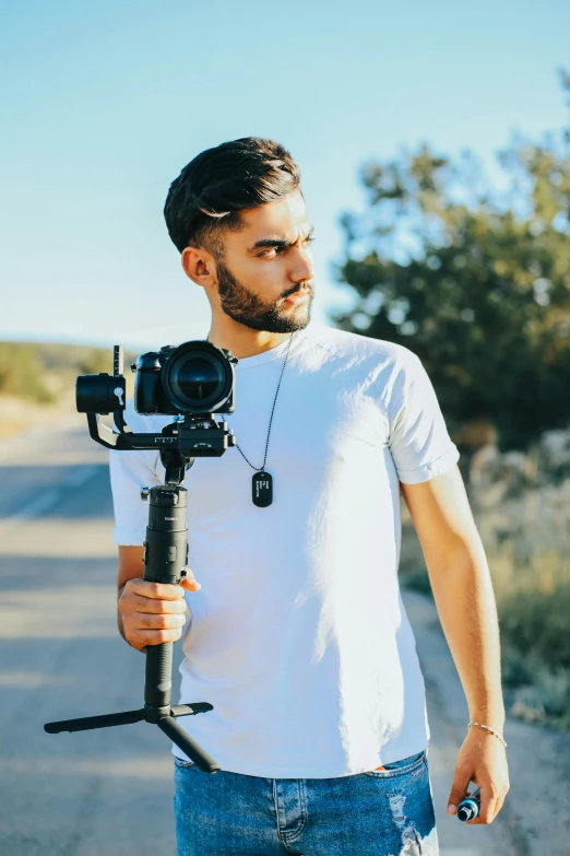 a man holding a camera on a tripod