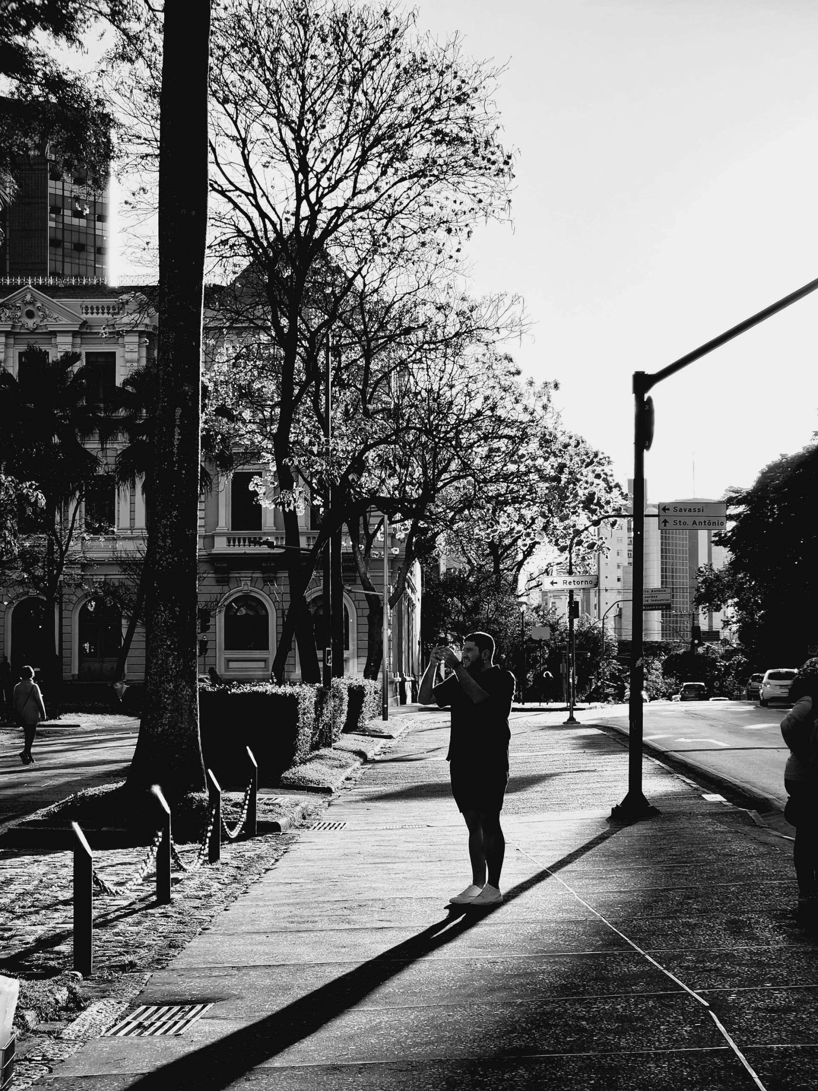 a black and white po of a man walking down a sidewalk