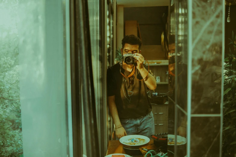 a person holding up a camera in front of a mirror