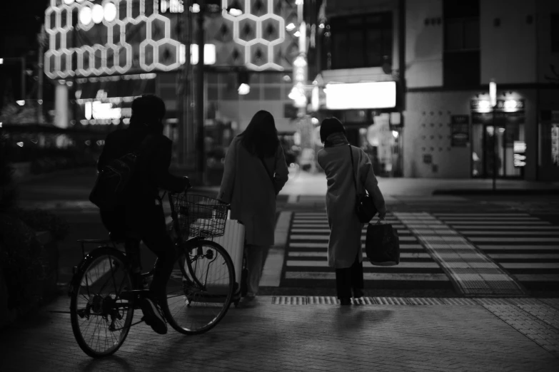 some girls with luggage walking a bike