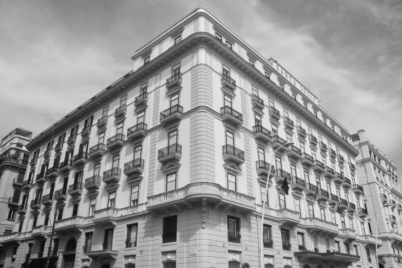 the building is white and gray with black balconies on top