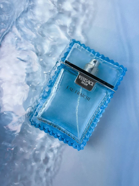 a perfume bottle lying on an icy surface