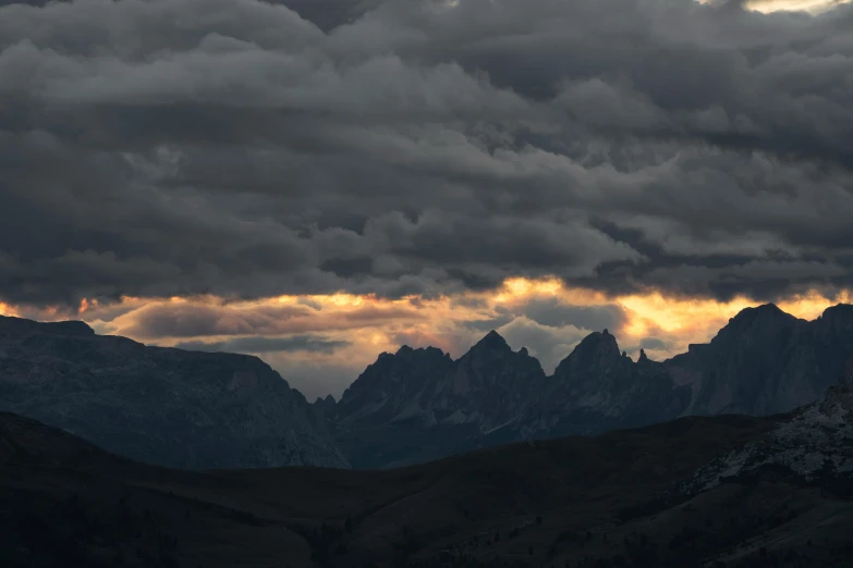 a large expanse of dark clouds with sun peeking out