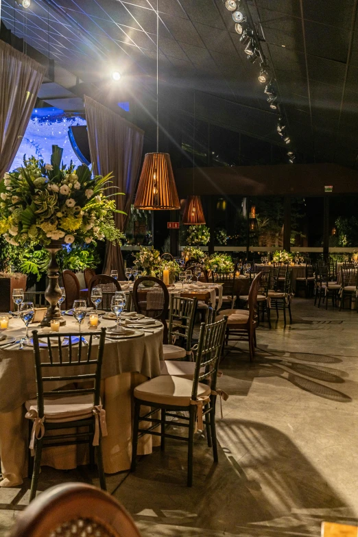 the inside of an elegant event venue with several round tables and chairs