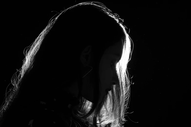 a black and white picture of a woman in front of a light