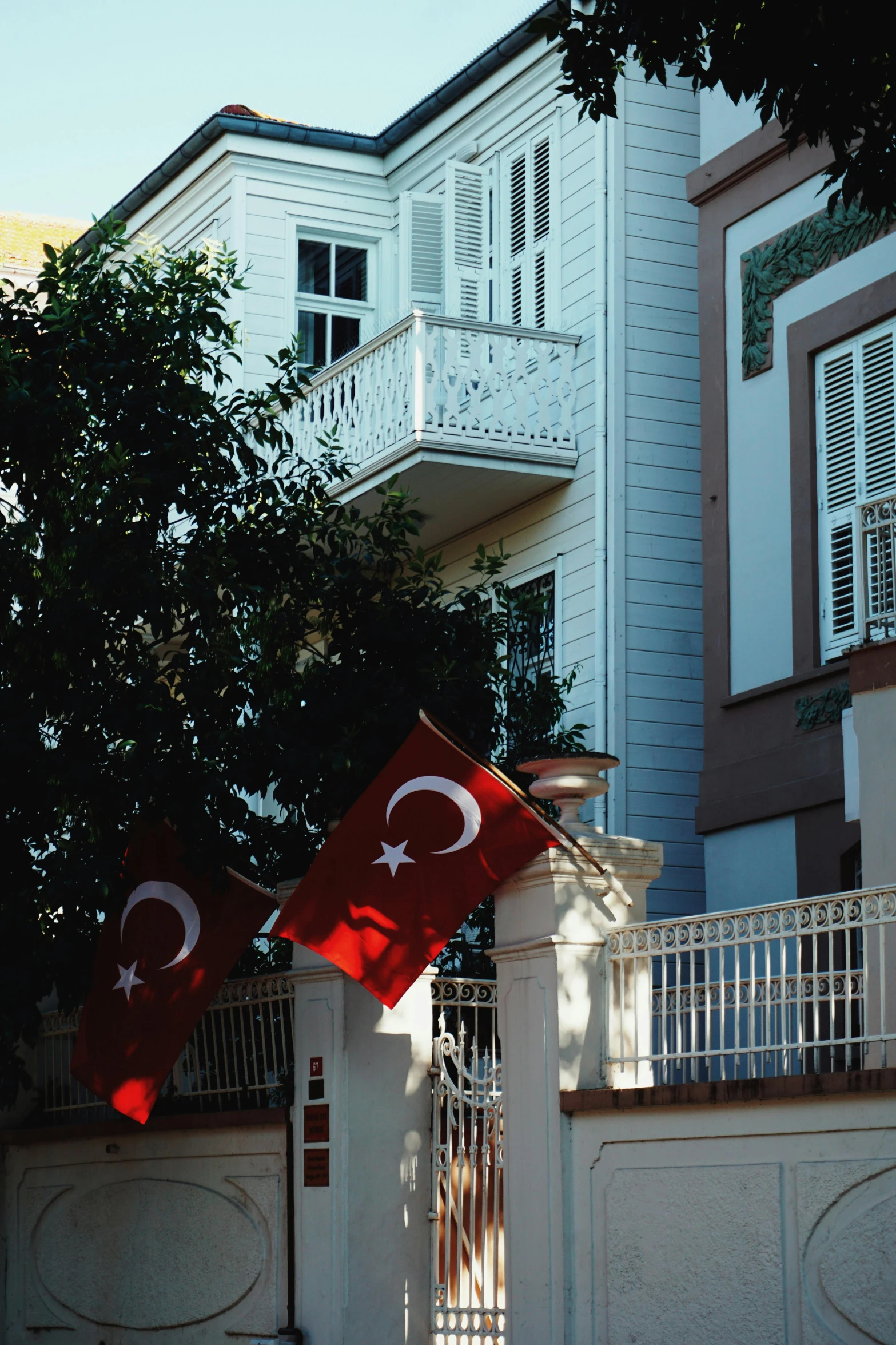 the two flags on poles are attached to the fence of the building