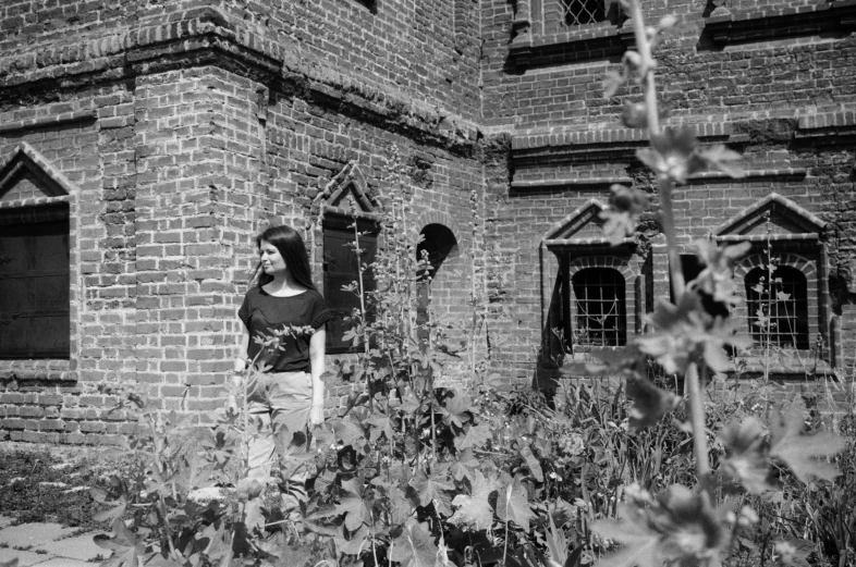 a woman standing outside of a brick building