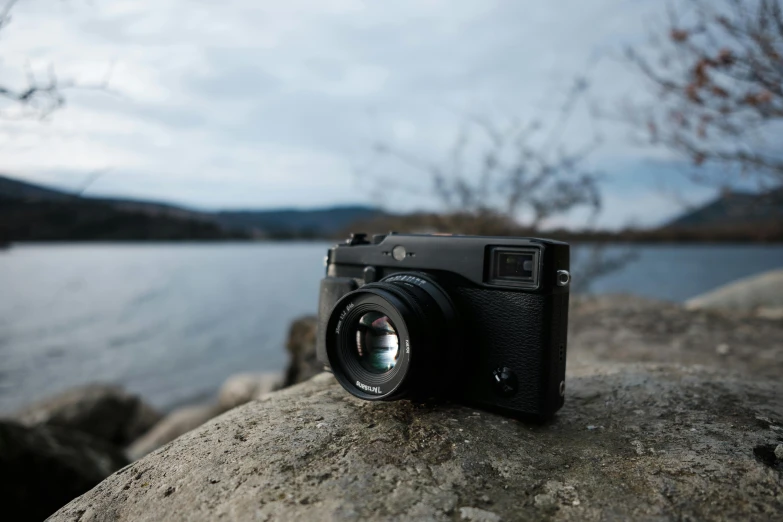 a camera resting on a rock by the lake