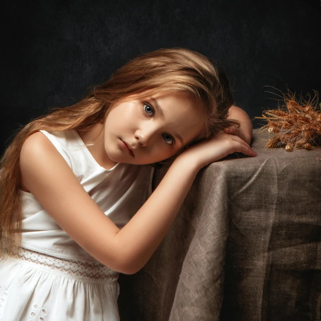 a little girl leaning on a brown chair with her hand on her shoulder