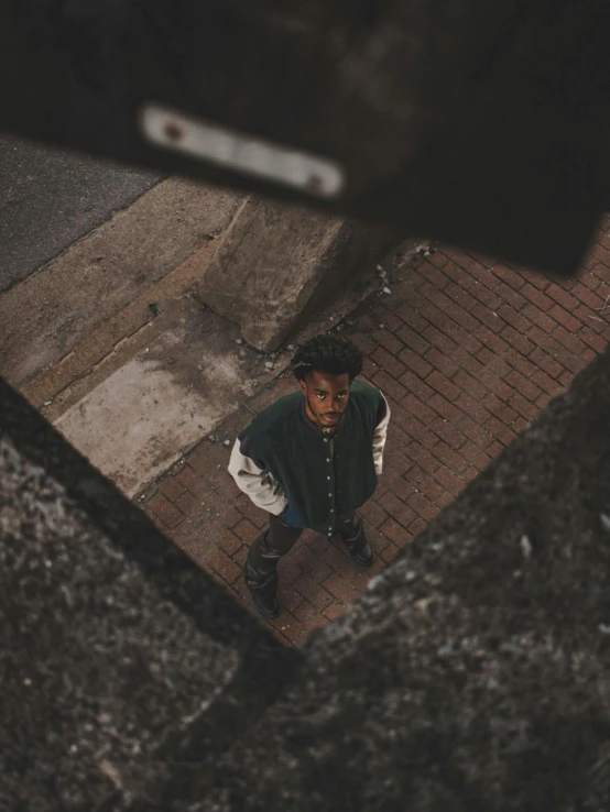 young man standing on the sidewalk looking down