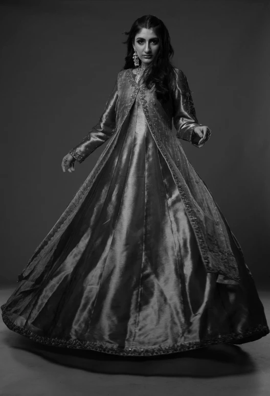 a woman standing in a long dress and dress