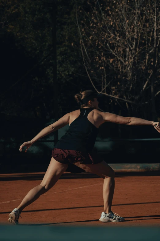 a woman in a tennis stance holding a racquet