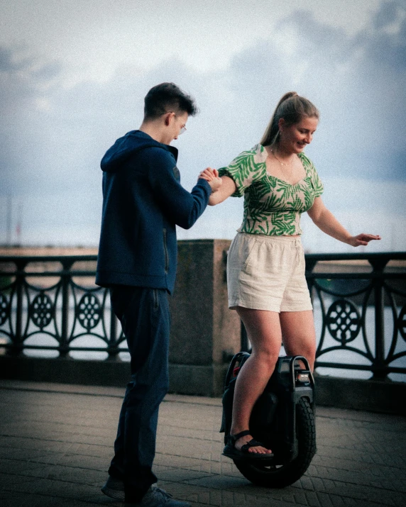 a man and a woman are standing on top of a suitcase