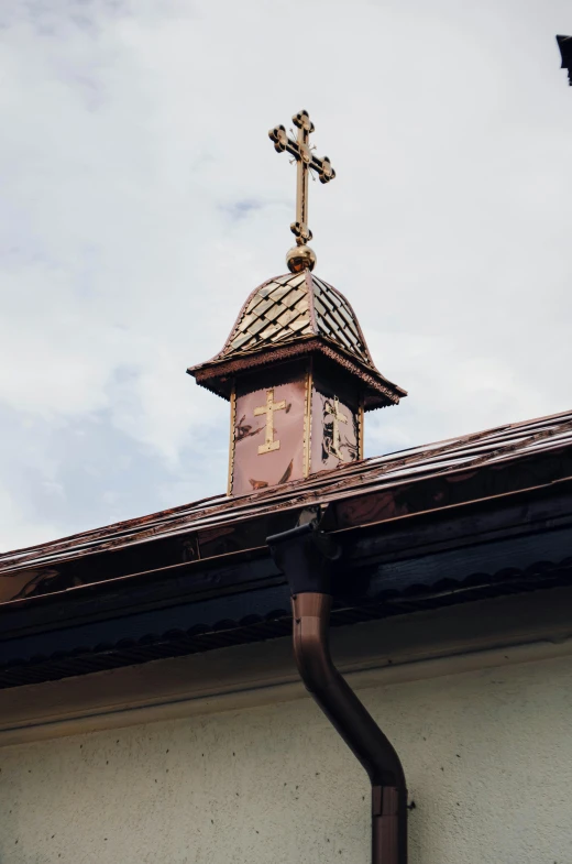 cross and roof on top of small house