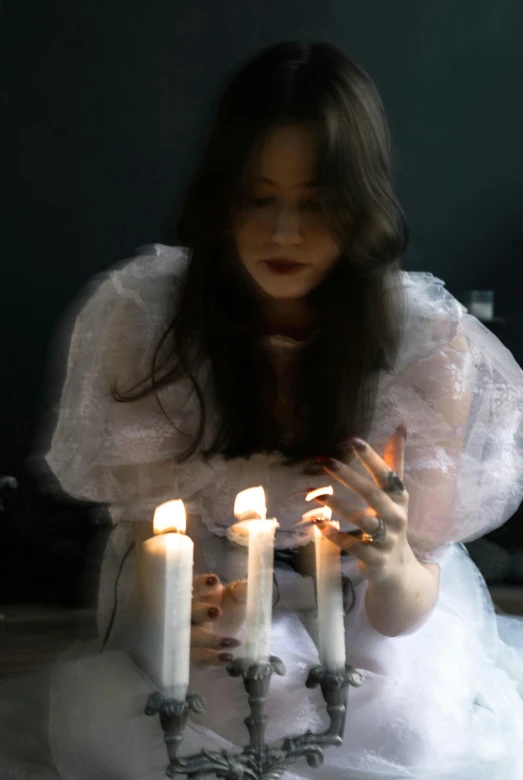 a young woman lights candles with her hands