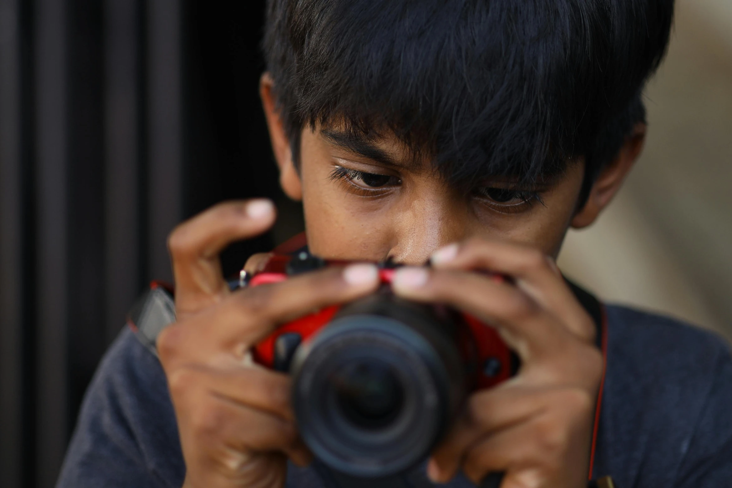 a young person taking a pograph with a red camera