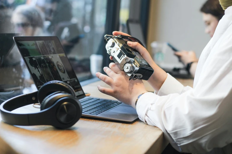 someone is using a laptop computer with an old radio next to them