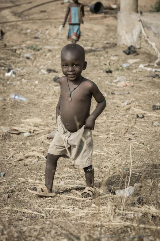 a  standing in a field with two children nearby