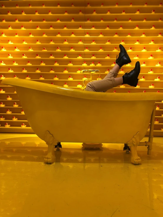 a person sitting in a bathtub with black shoes