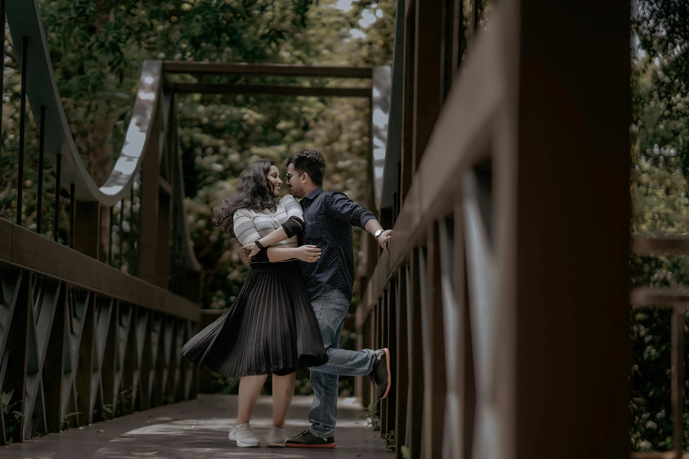 a woman standing next to a man on a bridge