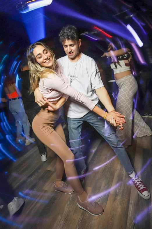 two people dancing in a dance room with the lights turned on