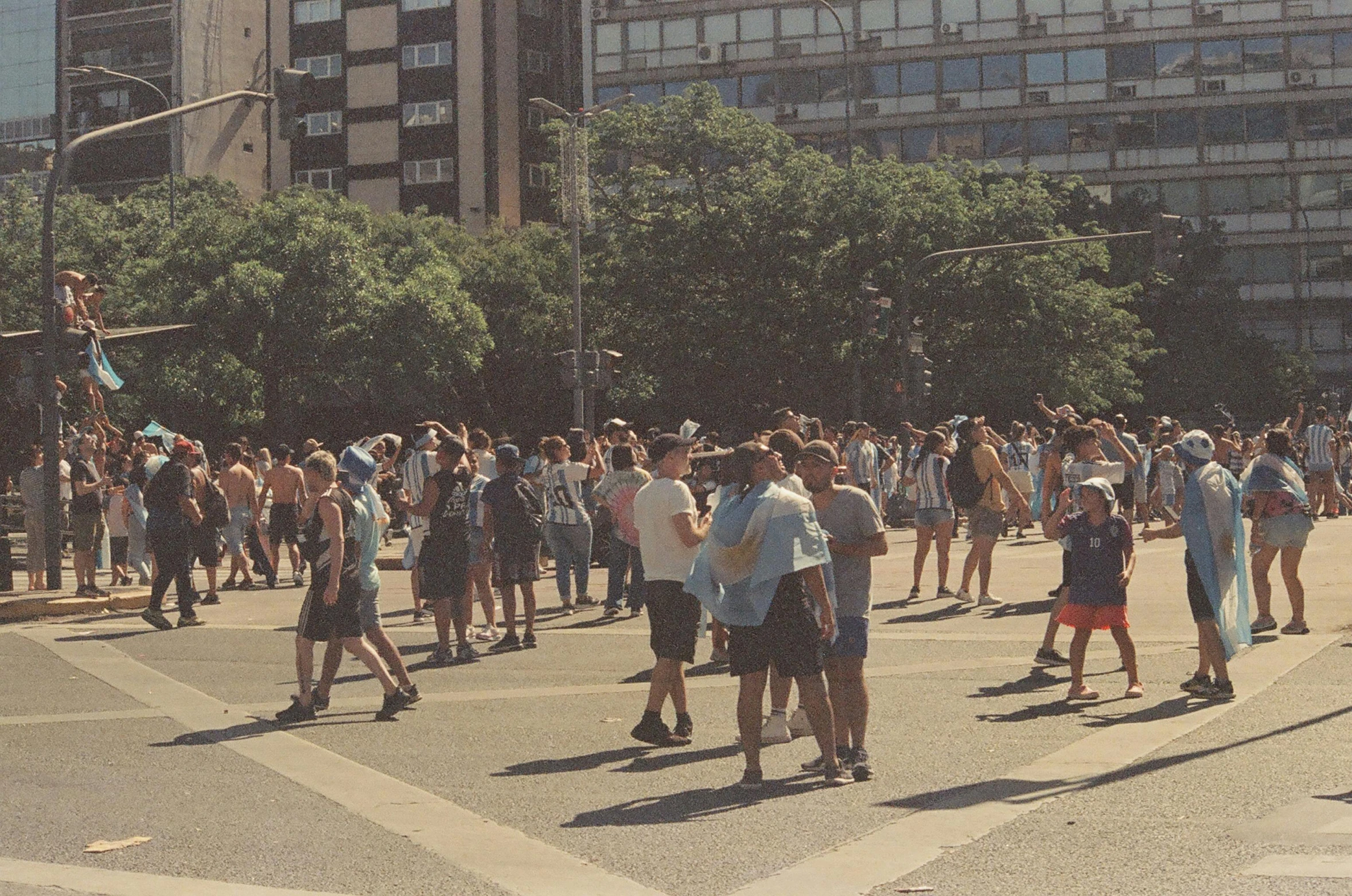 a crowd of people are standing in the middle of a street