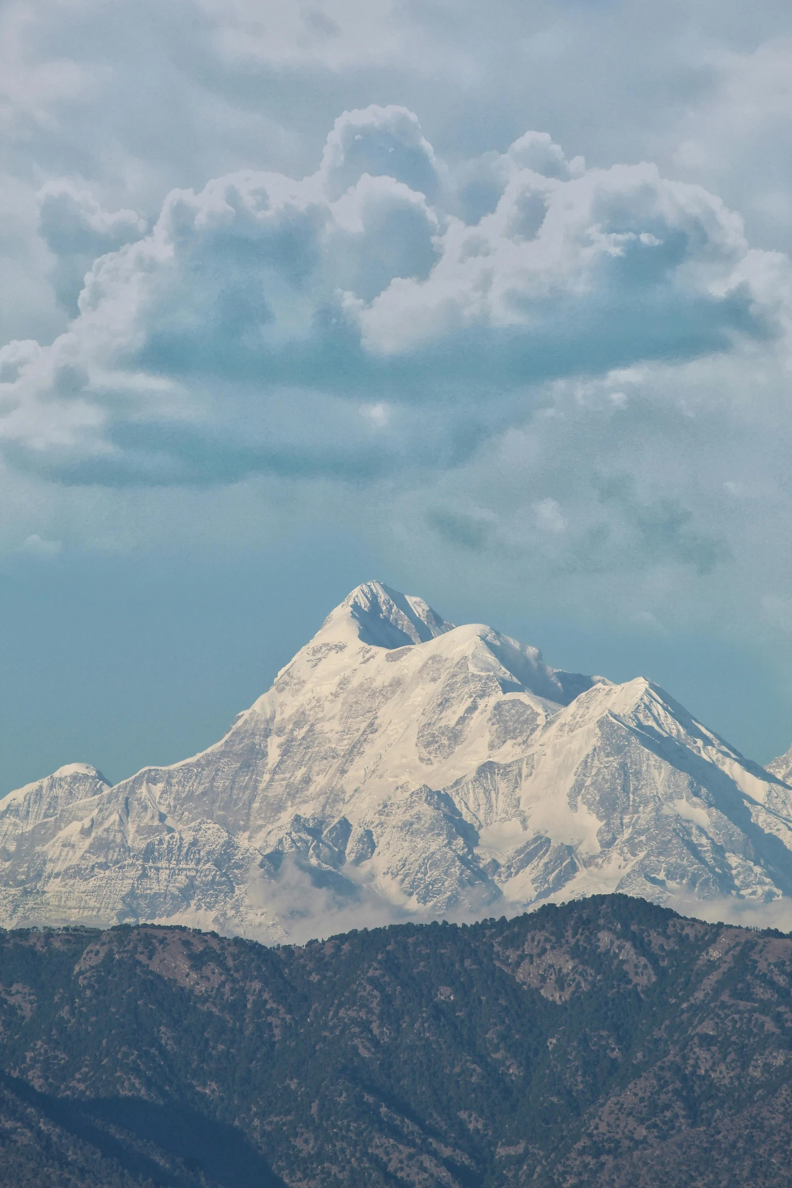 a mountain with some clouds flying over it