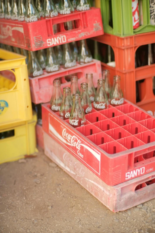 many coca cola bottles sit in crates with each being filled with coke