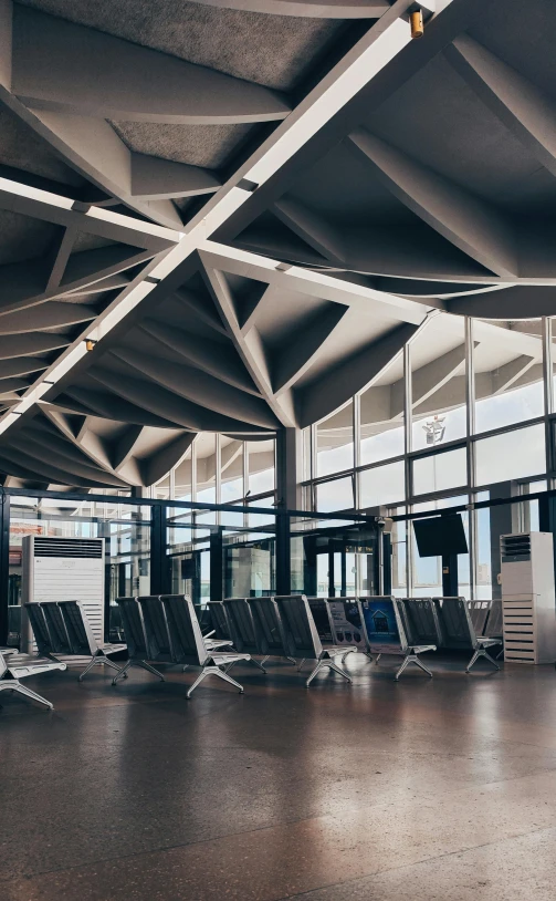 an airport waiting area with rows of chairs and a few tables