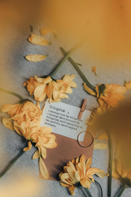 an open book on top of flowers with a keychain