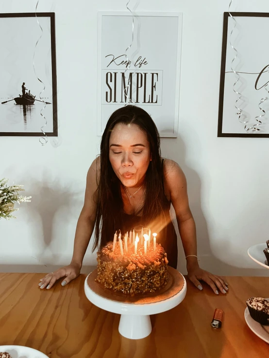 a young woman blowing out a candle on her cake