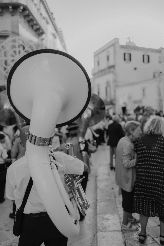 a person with a hat and tie walking on the sidewalk