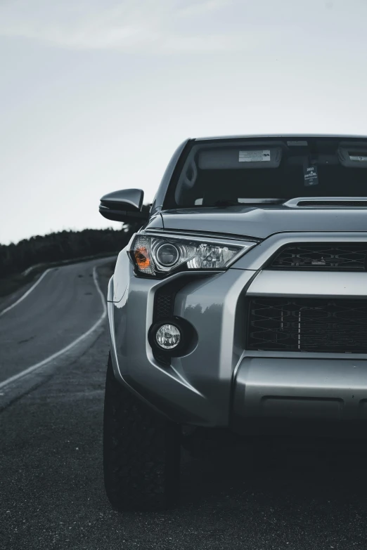 a gray sports utility truck parked by a road