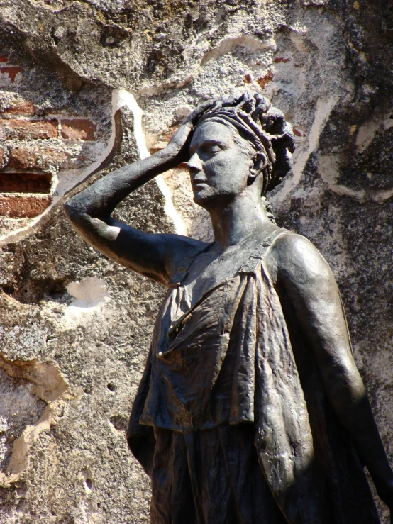 the statue is touching her hair on top of her head