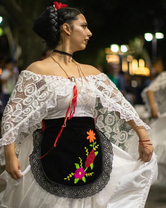 woman in white top and black and white dress holding purse