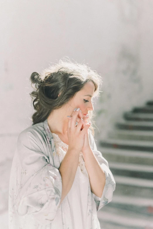 a woman in a white dress has a tissue on her hand