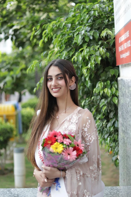 a young lady holding a bouquet and smiling