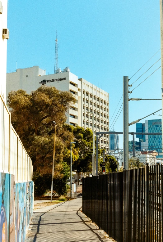 a street with buildings, power lines and a fence