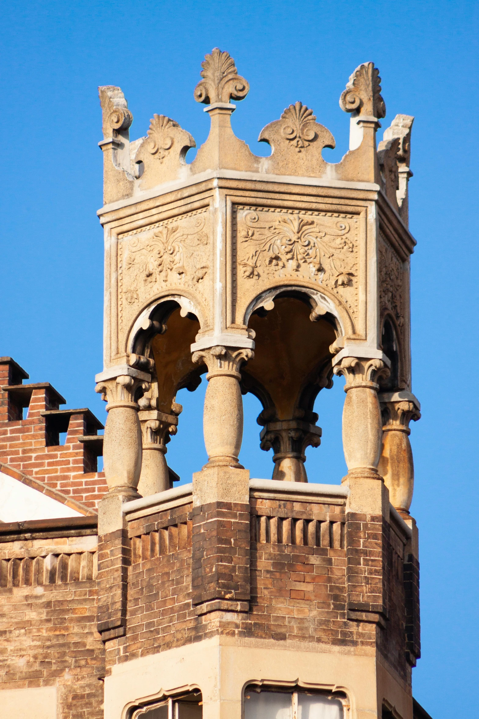 a tall clock tower with two windows and gargoyles