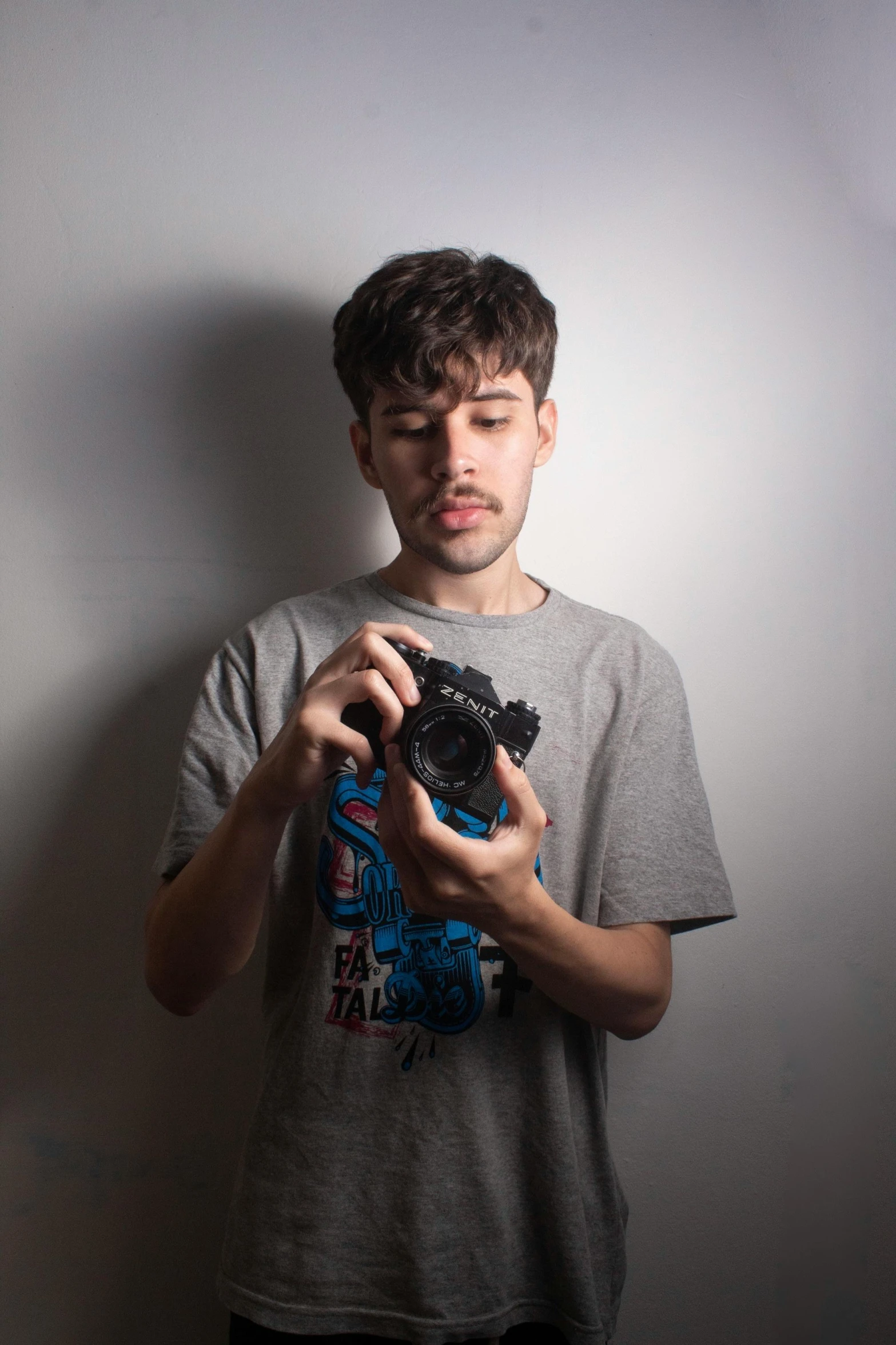 a man holding a small camera and making a funny face