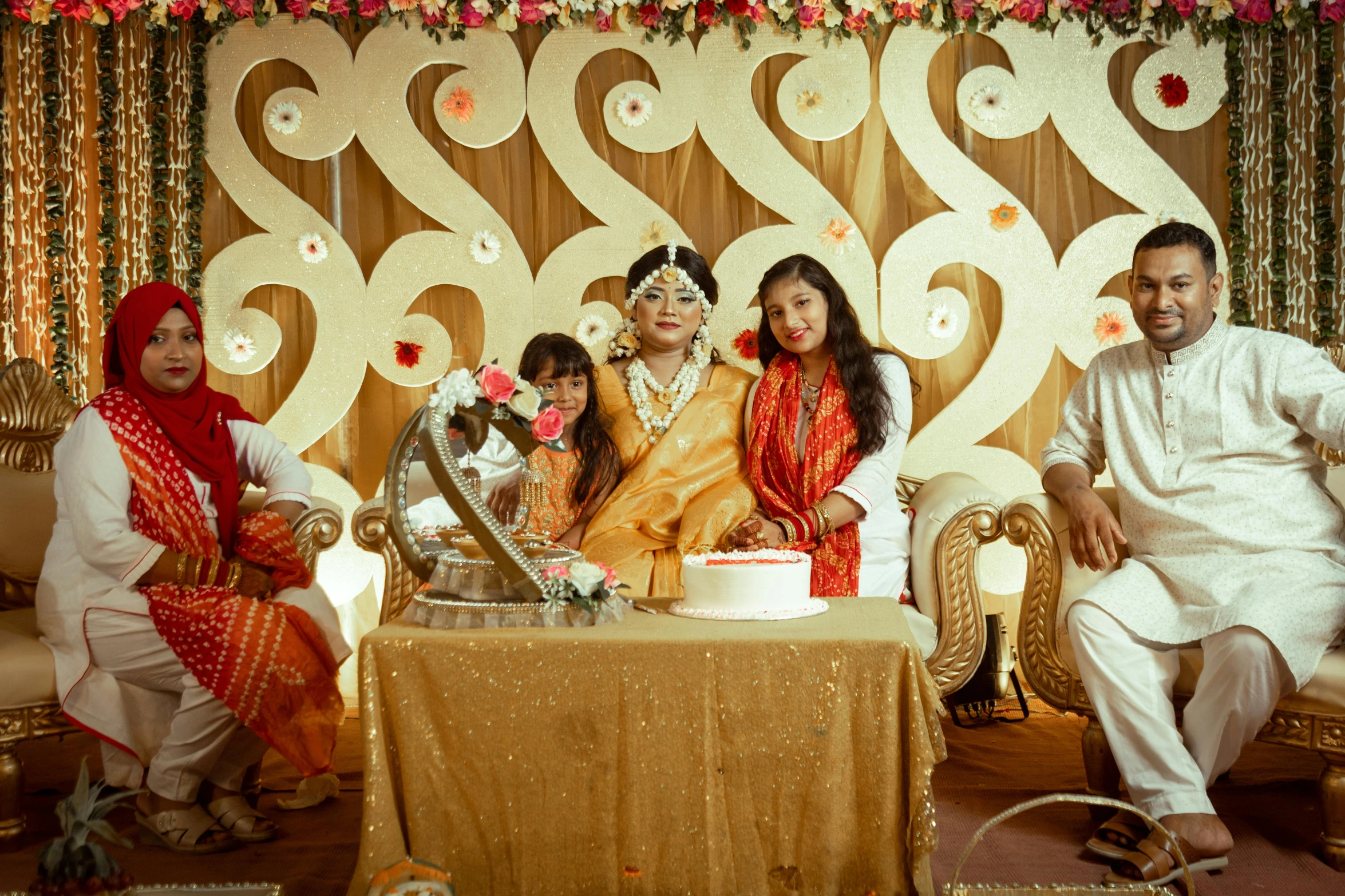 a group of people in traditional indian dress standing around a table