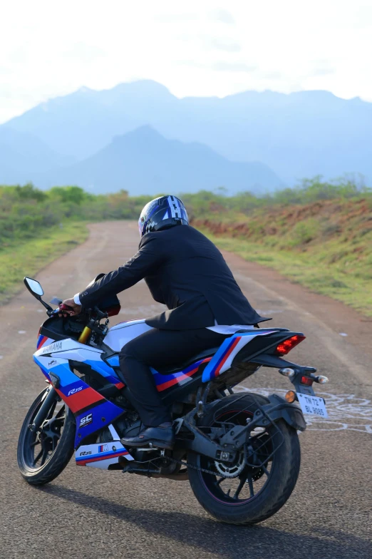 the man is riding his motorcycle on the dirt road